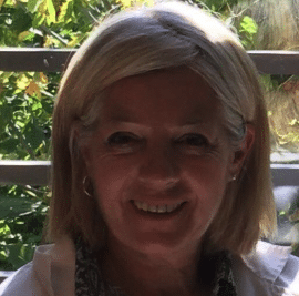 Smiling woman with gold earrings and shoulder length blonde hair