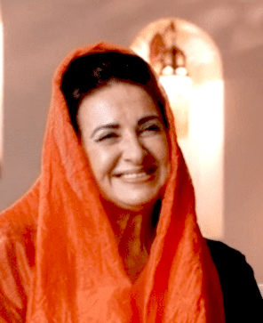 A radiant smiling woman in an orange head scarf